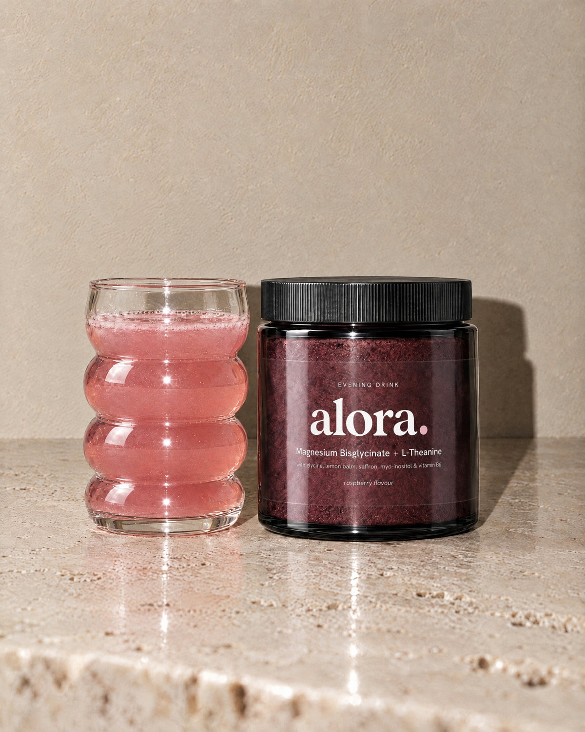 ALORA jar beside a glass of the raspberry-pink evening drink (illustrative image)
