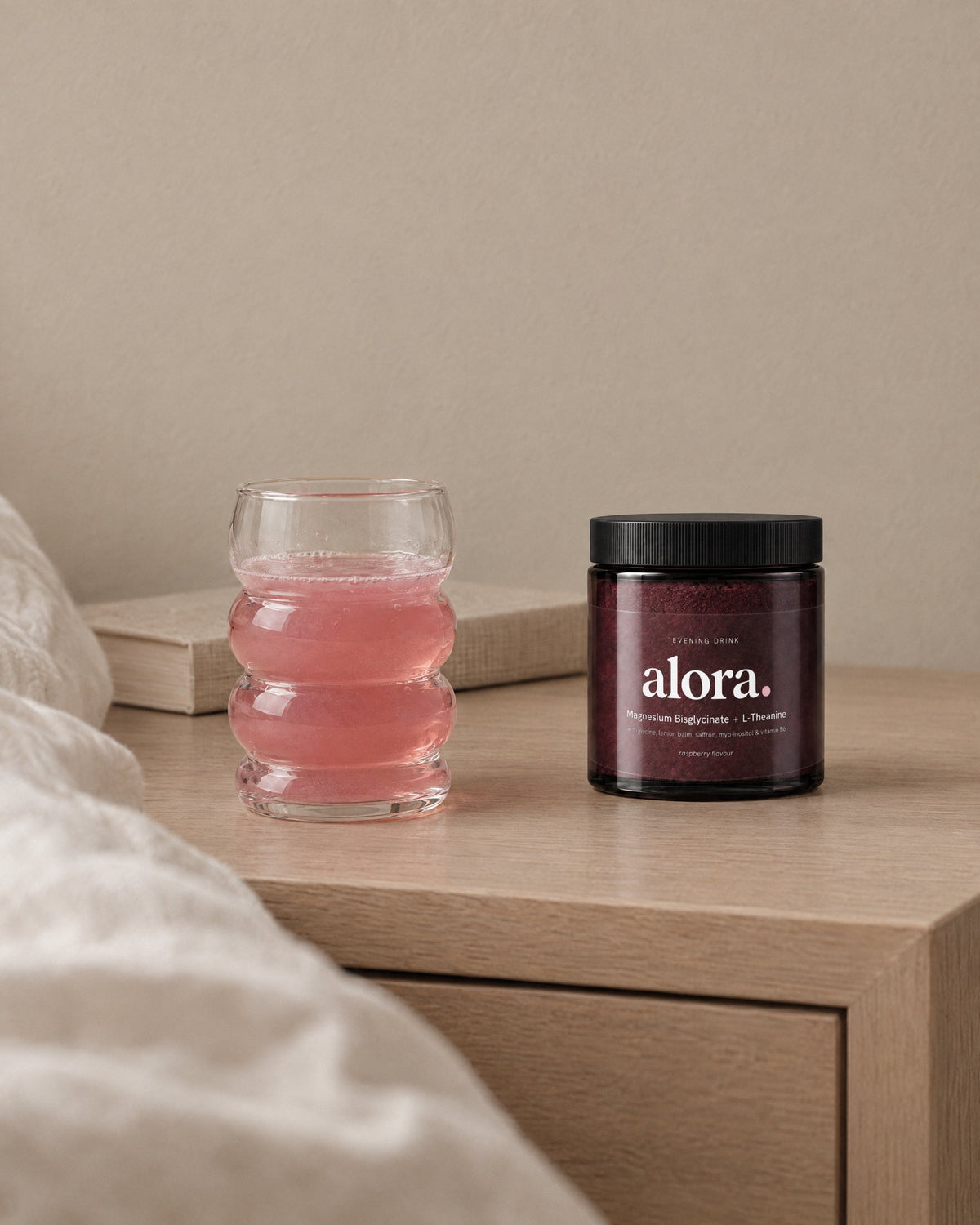 ALORA jar and a glass of the drink on a bedside table (illustrative image)