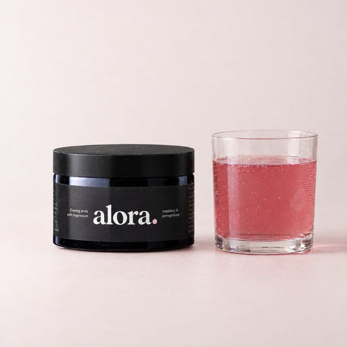 ALORA jar next to a glass of the raspberry-pink drink (illustrative)