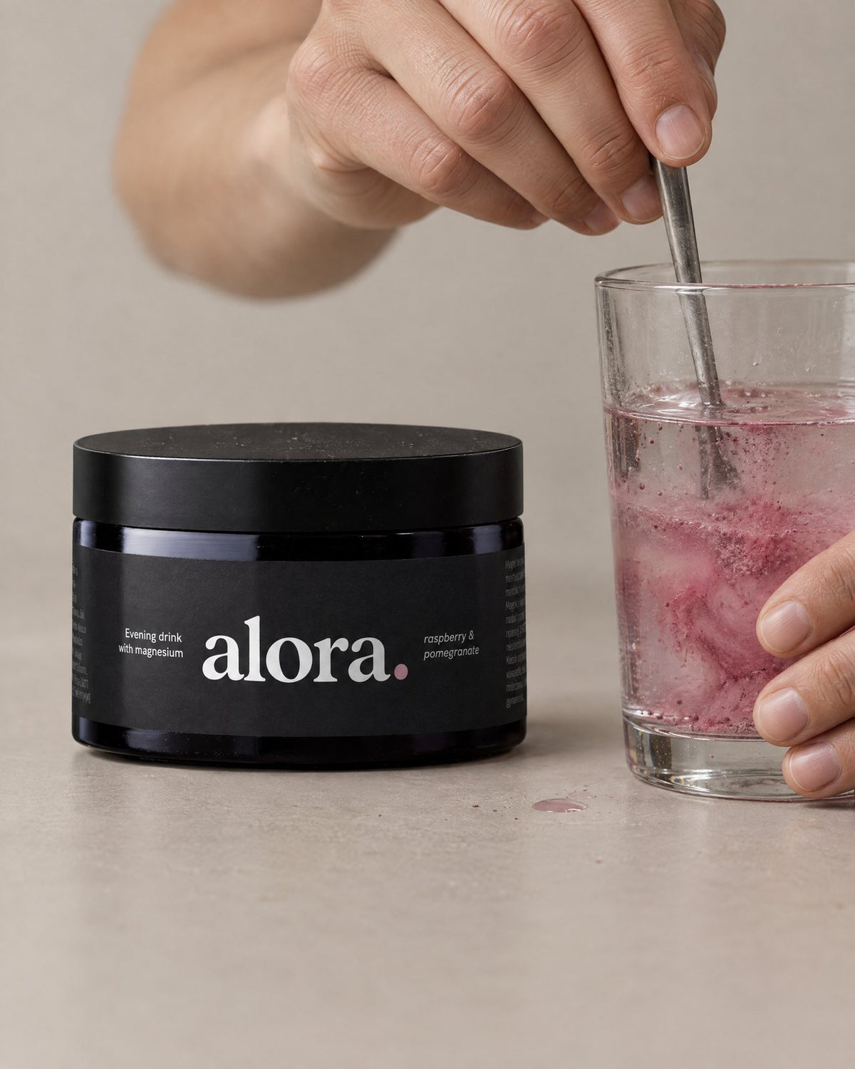 Stirring ALORA powder into a glass of water (illustrative)
